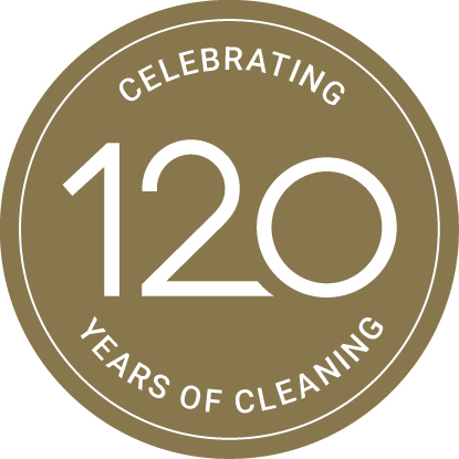 Circular gold badge celebrating 120 years of cleaning with bold white text, marking legacy and innovation.
