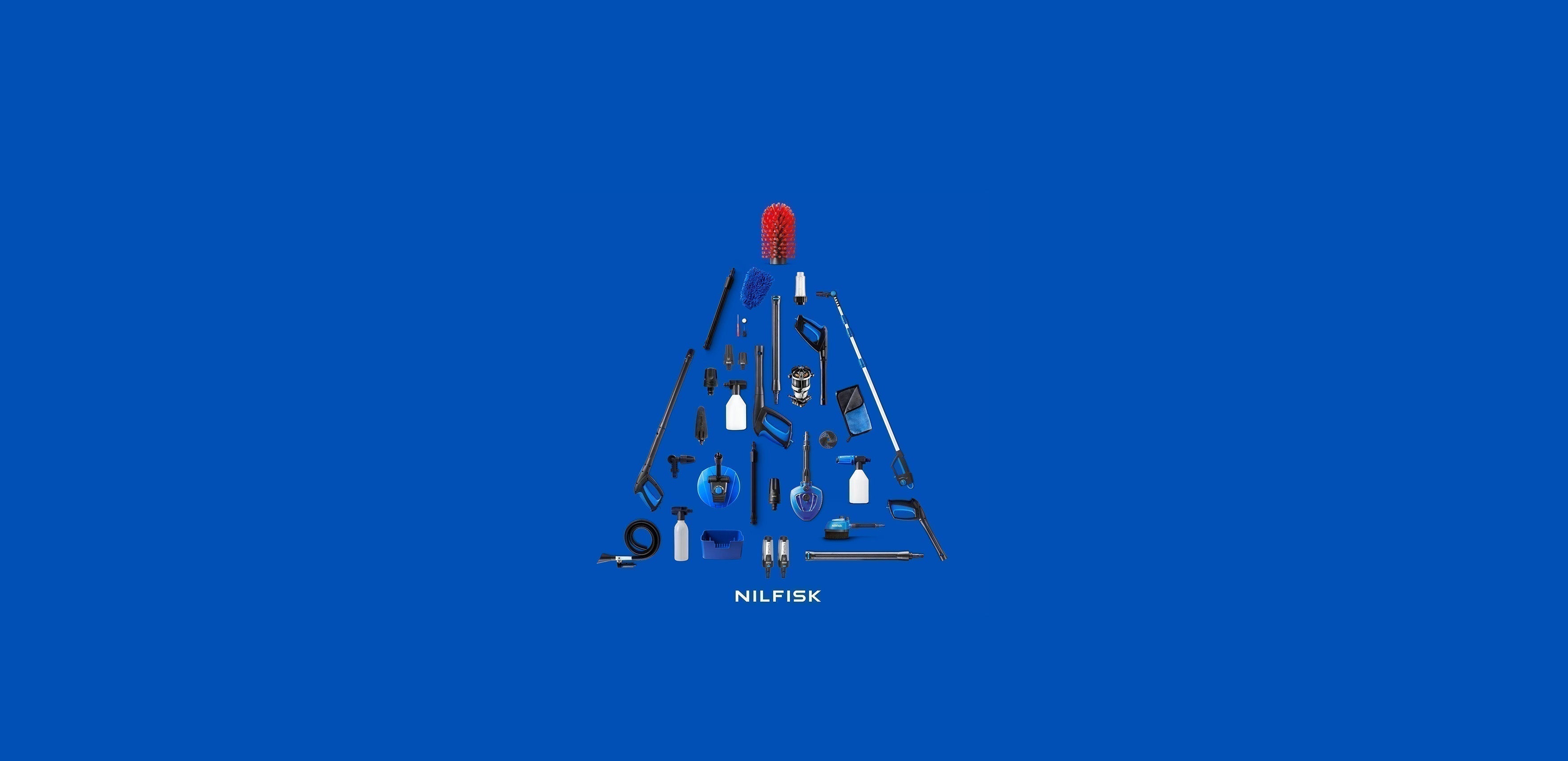 Nilfisk cleaning tools arranged as a festive Christmas tree on blue background, holiday gift idea.