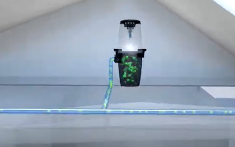 Nilfisk central vacuum mounted in attic, sleek black unit with green accents, connected to blue hose, clean indoor air solution.